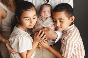siblings snuggling baby