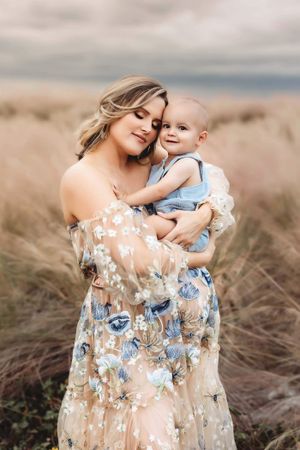 mom snuggling older child during maternity session