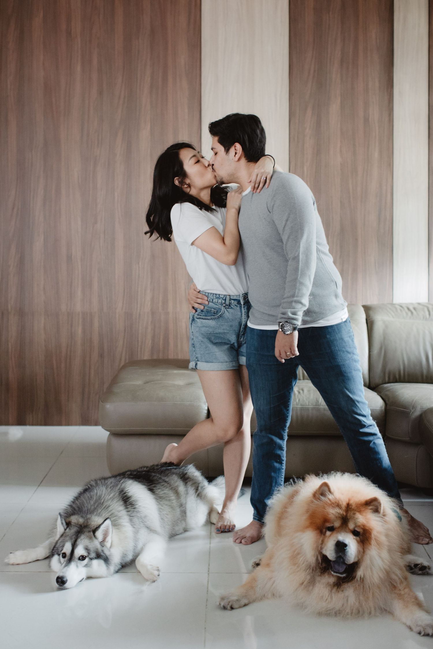 couple kissing with their dogs