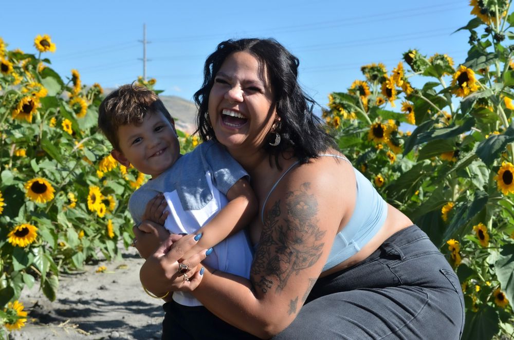 Playful moment in a sunflower field with bright yellow blooms in the background.