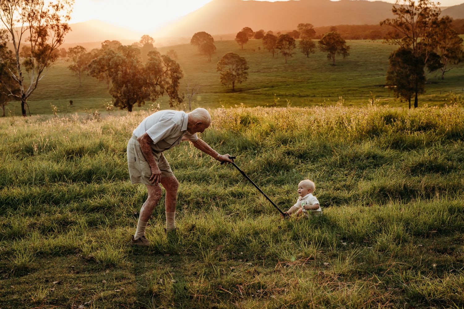 A heartwarming playtime moment in a sunlit field during golden hour.