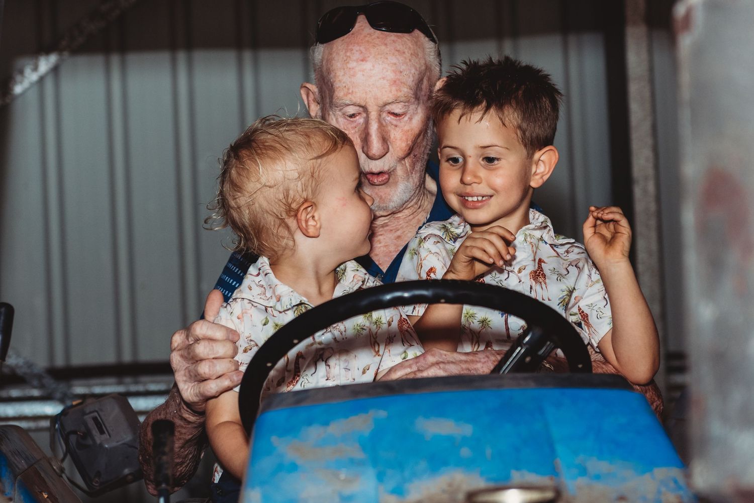 Playful moment shared while sitting in an old blue tractor.