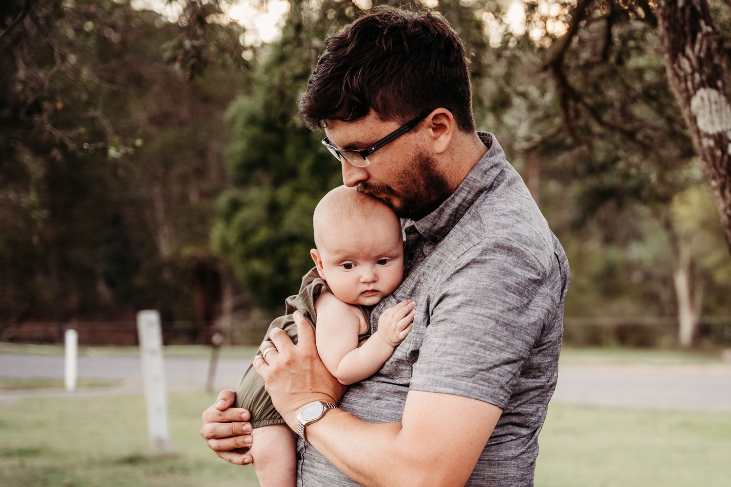 Gentle embrace in soft natural light outdoors.