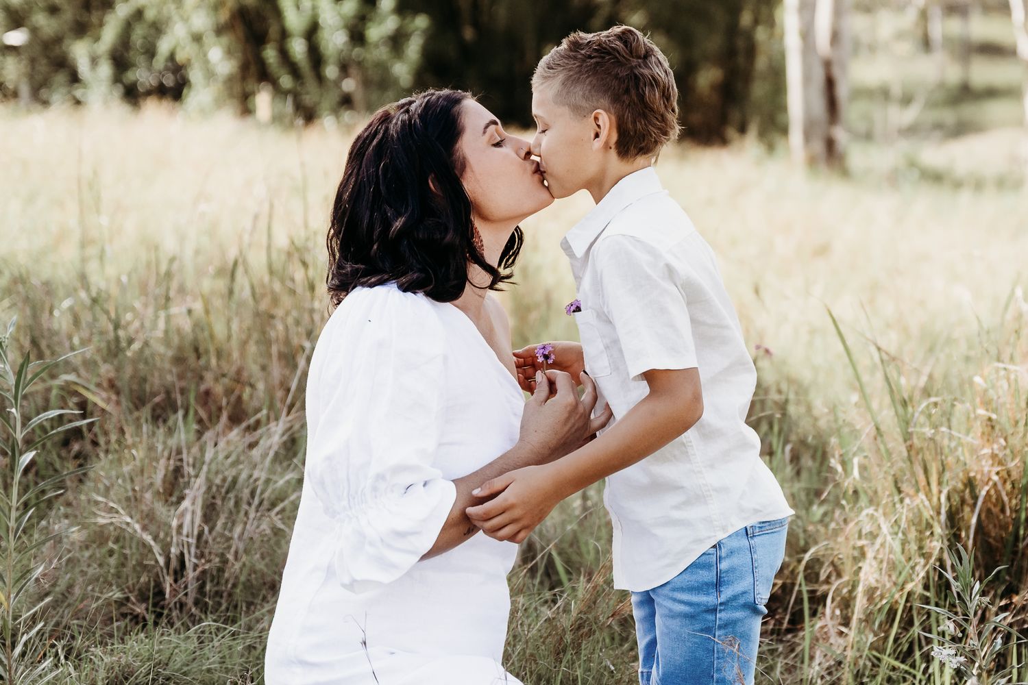 Sweet moment between parent and child outdoors in a sunny field.