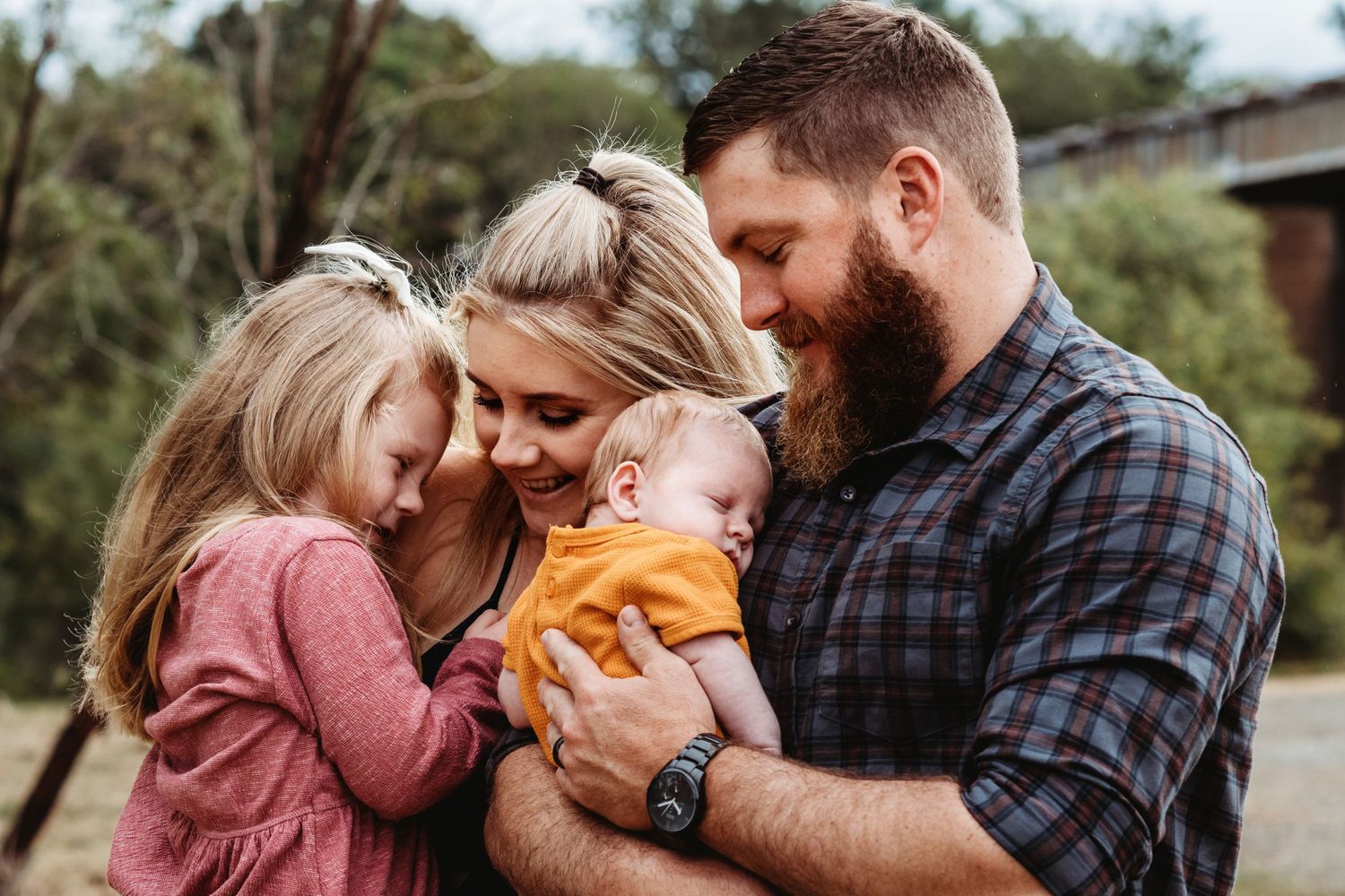 An intimate family moment shared outdoors in warm autumn light.