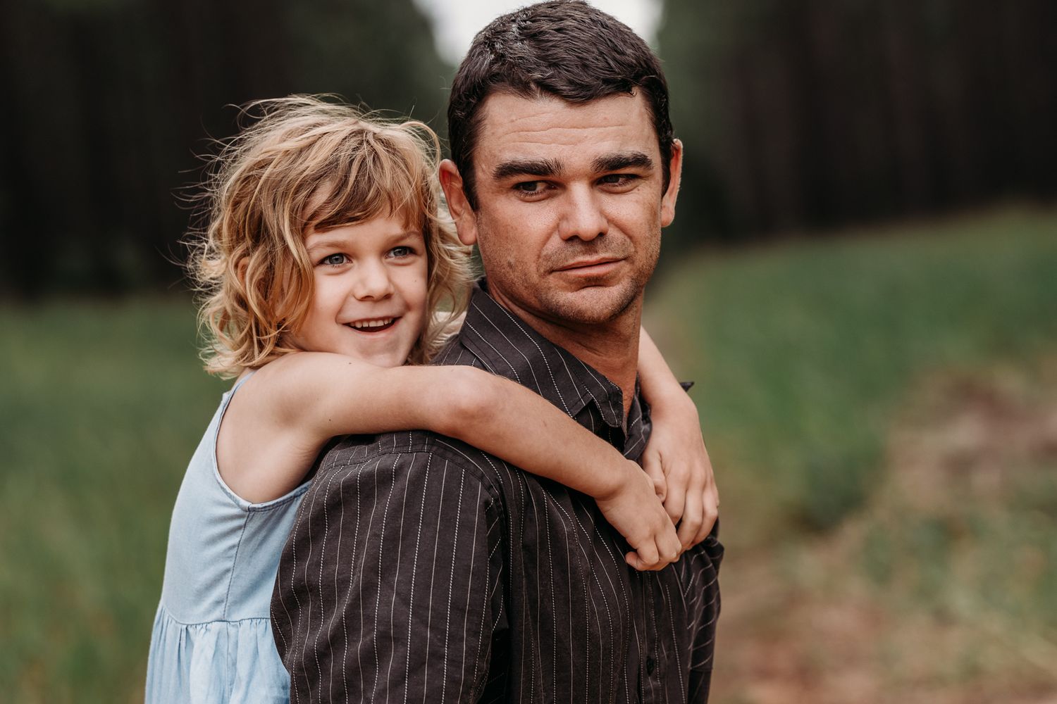 A playful piggyback ride moment captured outdoors in natural lighting.