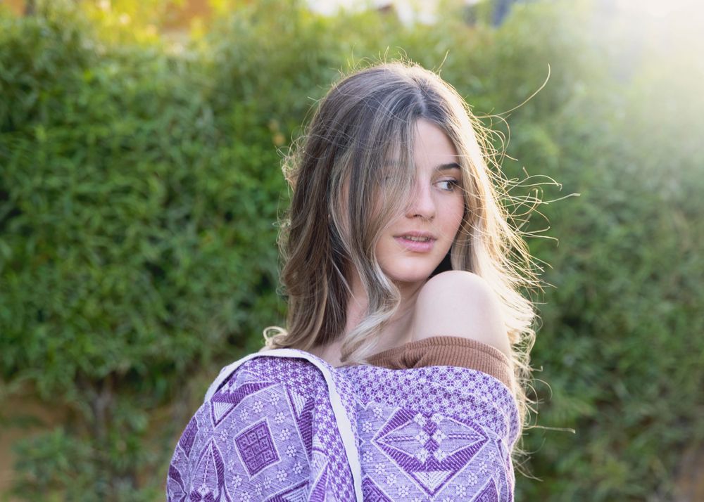 Image of a beautiful girl wrapped in a blanket enjoying the golden hour sun raise.