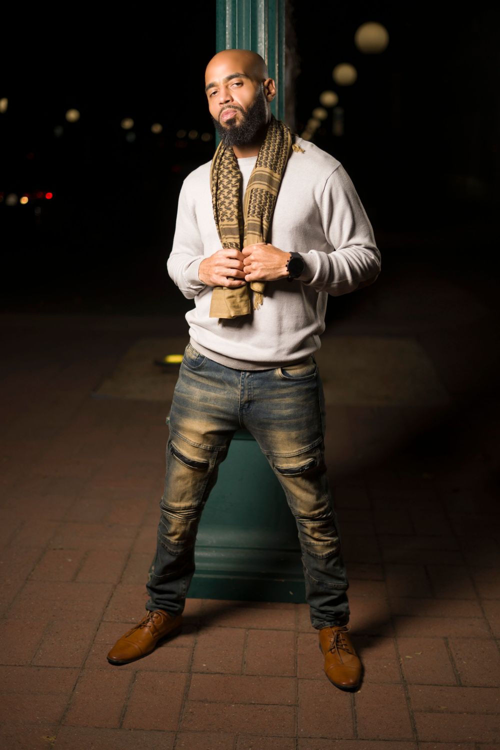 Male model with brown and gold scarf posing for photoshoot