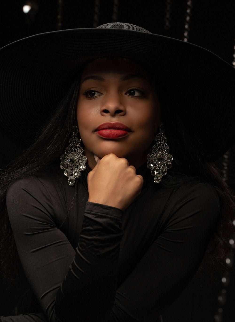 Black woman with red lipstick in one piece and large diamond earrings in editorial photoshoot