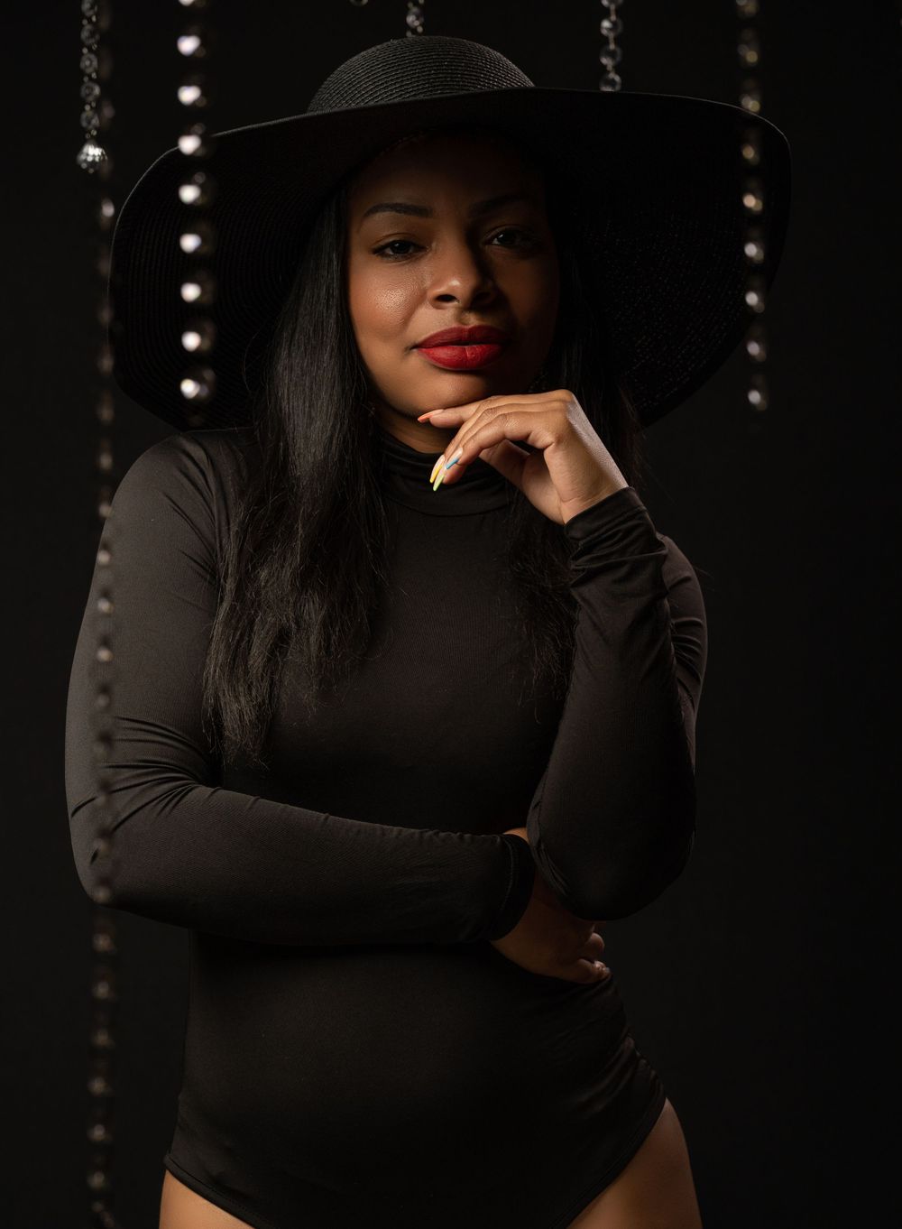 Black woman with red lipstick in one piece and diamond in the background of editorial photoshoot