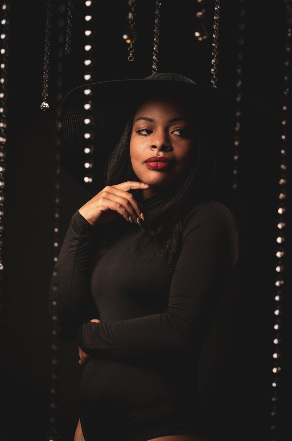 Black woman with red lipstick in one piece and diamond in the background of editorial photoshoot