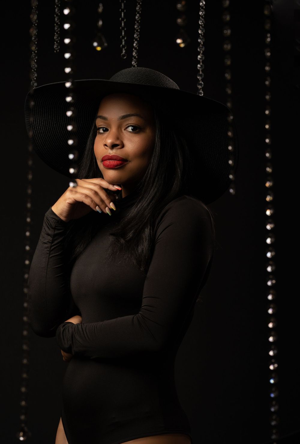 Black woman with red lipstick in one piece and diamond in the background of editorial photoshoot