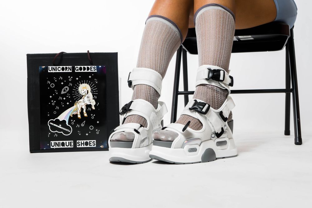 Photo of shoebox, custom sneakers and legs of a model with knee high socks