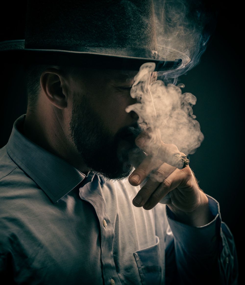 mysterious man in a cloud of smoke and a topcoat