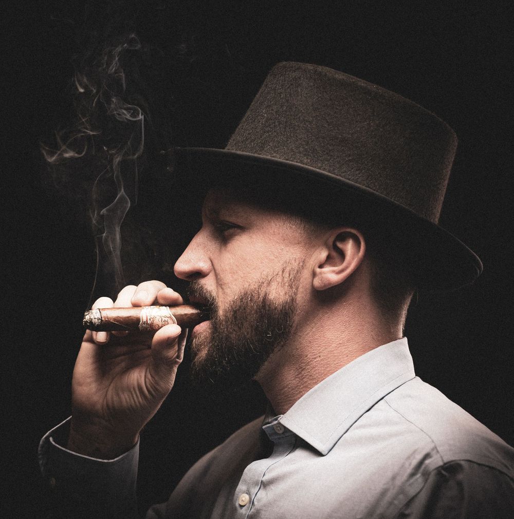 Black top hat and man smoking a cigar headshot