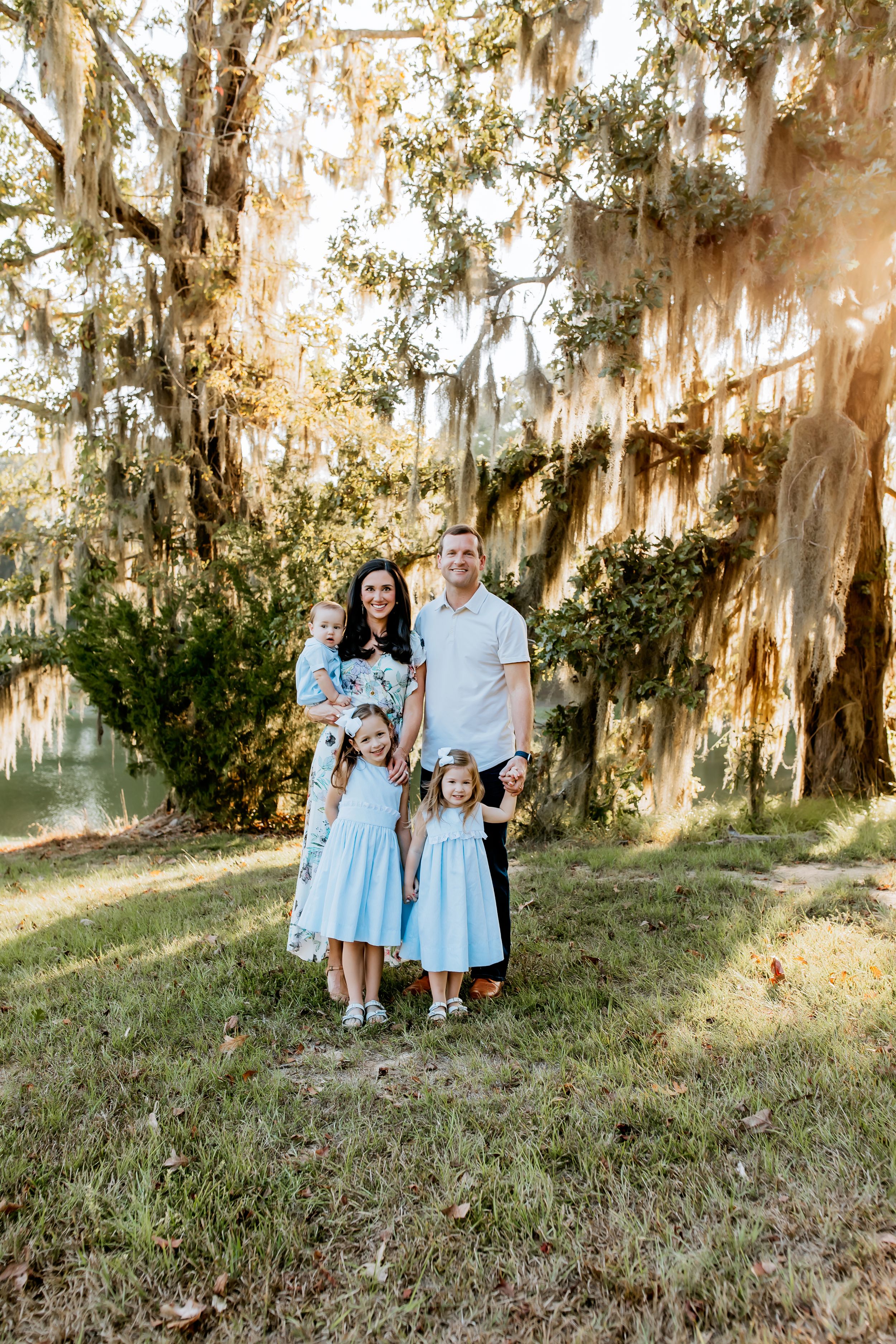 Family portrait under Spanish moss draped trees in soft natural light.