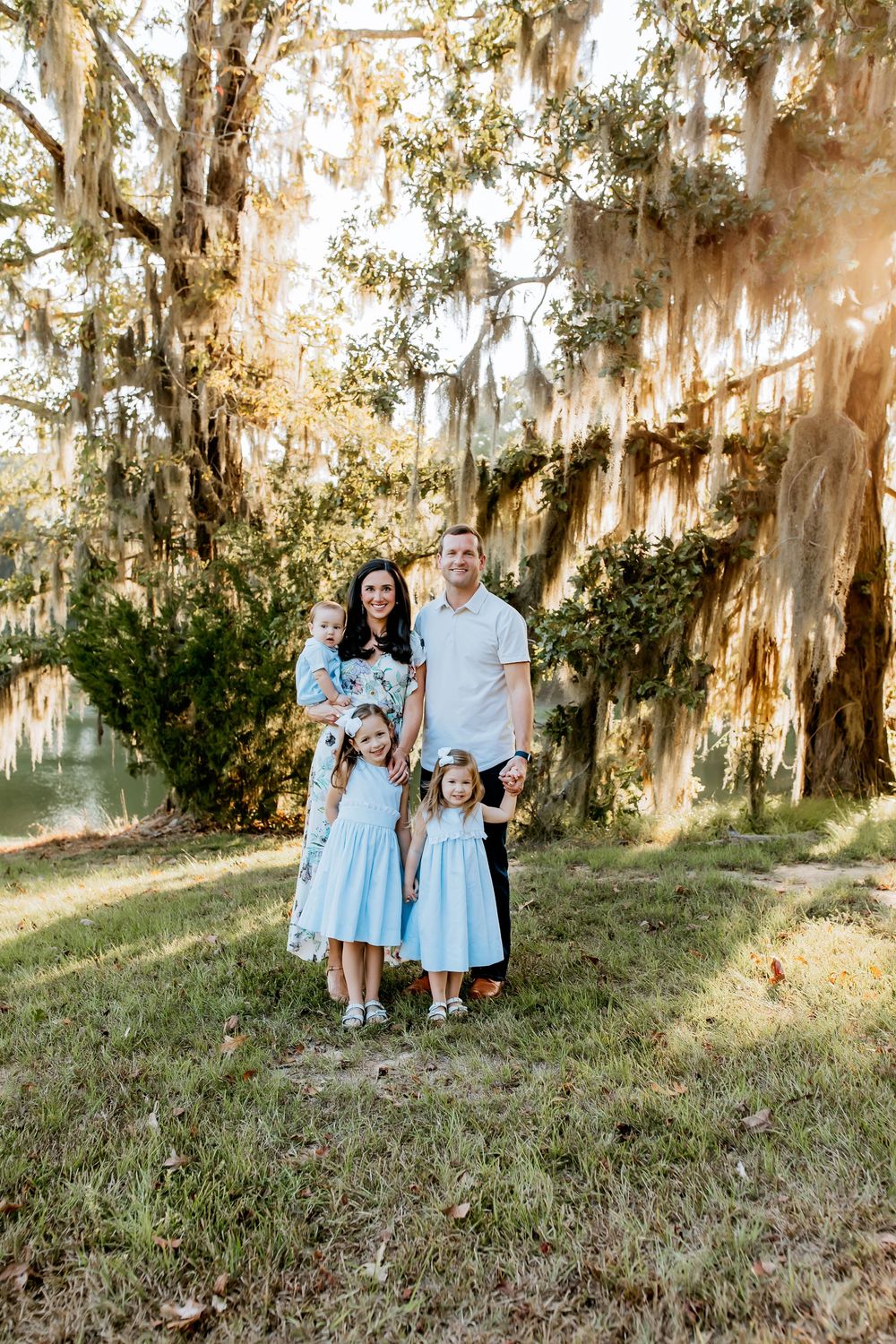 Family portrait under Spanish moss draped trees in soft natural light.