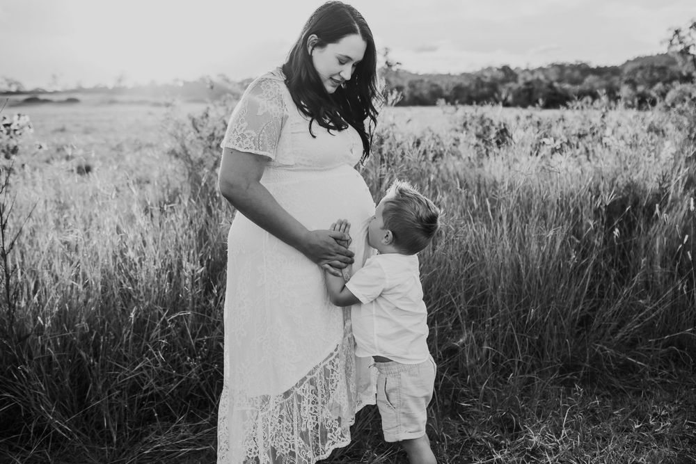 Black and white family portrait session in tall grass field.