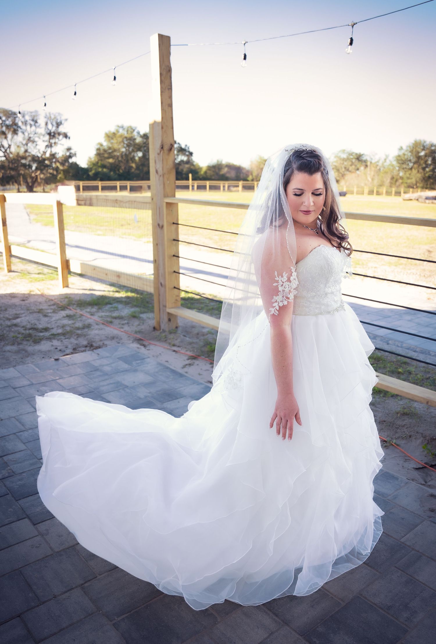Flowing white wedding dress captured in motion on outdoor patio.