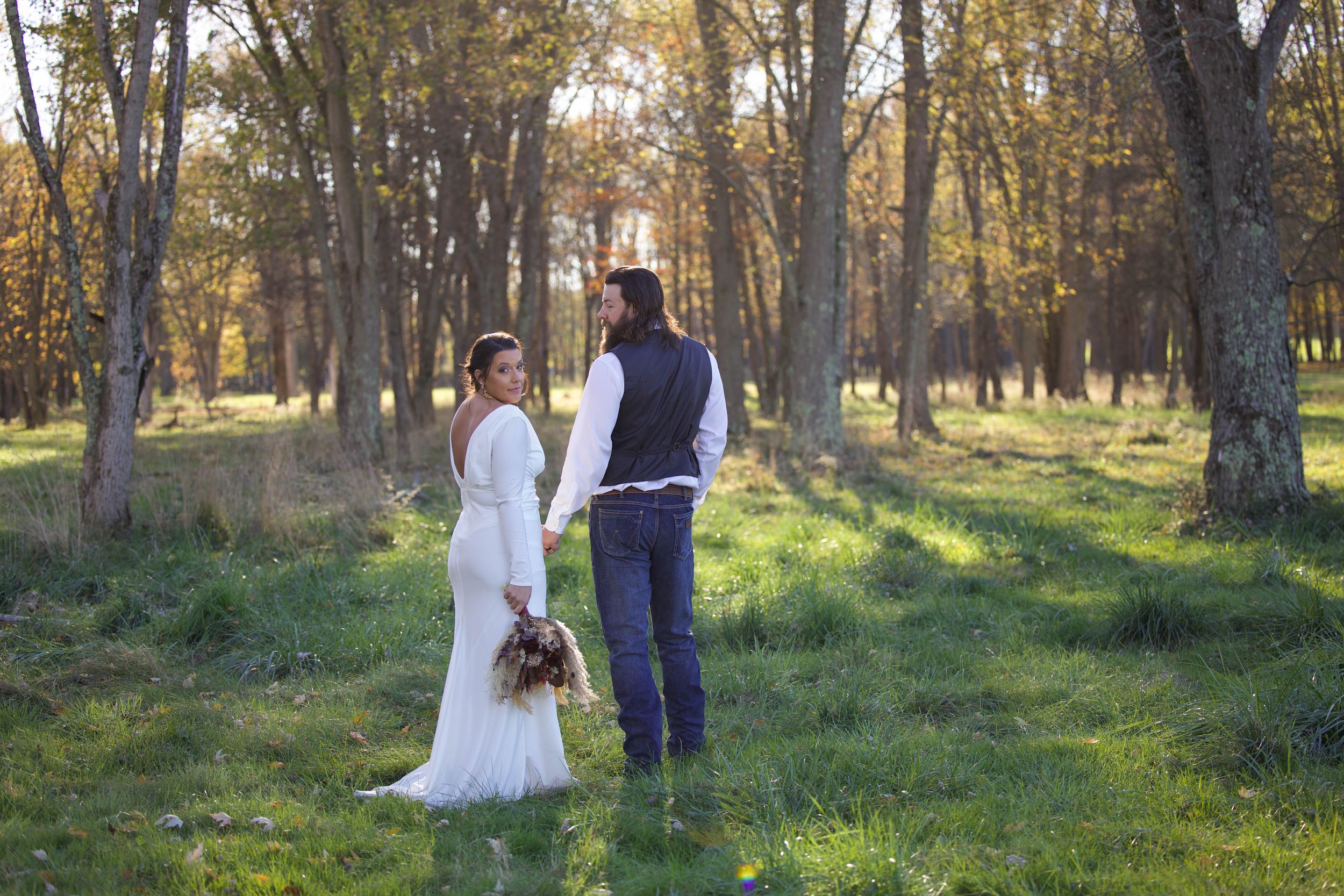 A bride looking over her shoulder into camera as groom looks at her