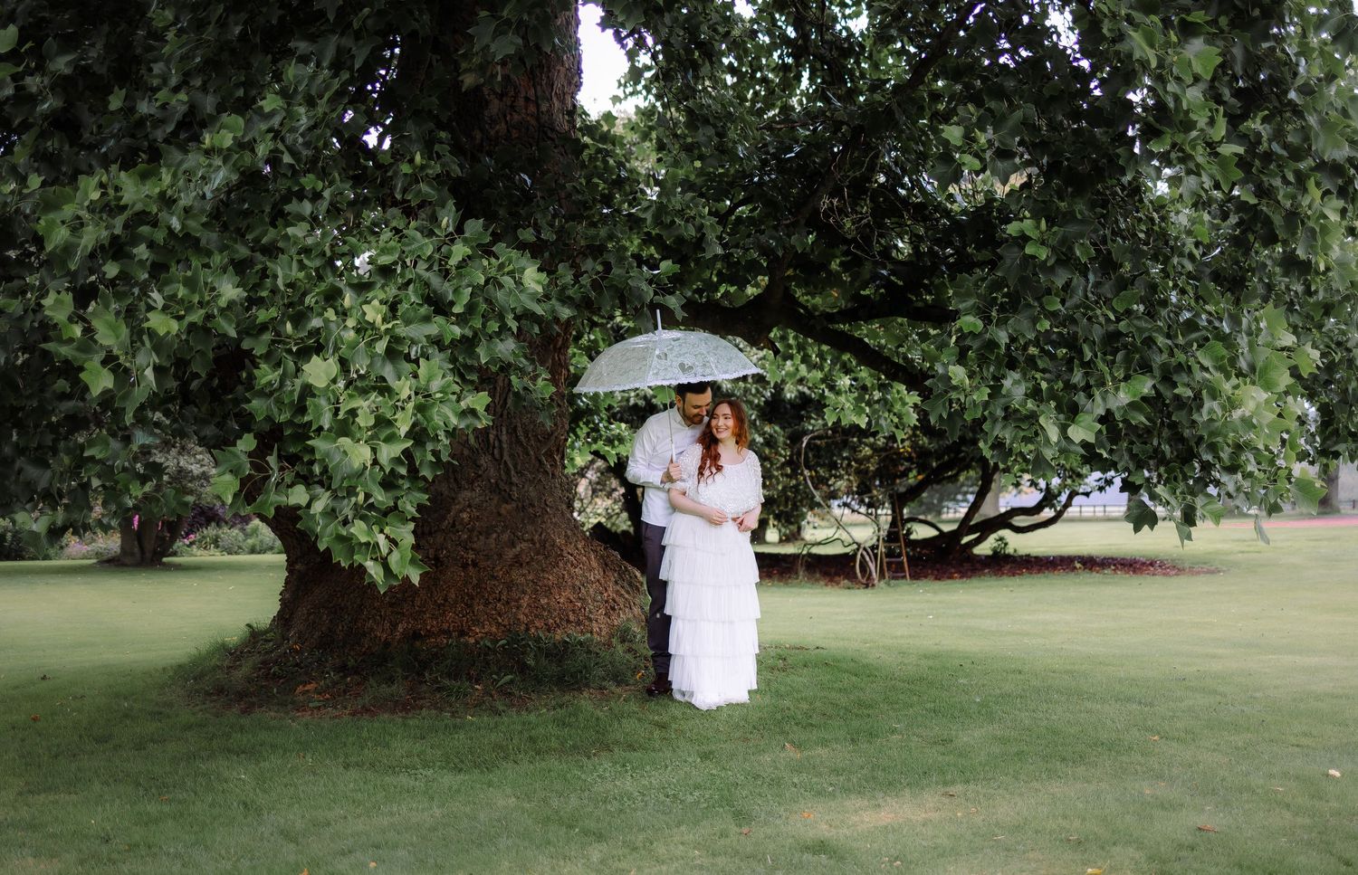 sheltering from the rain under the trees Cumbria wedding photographer