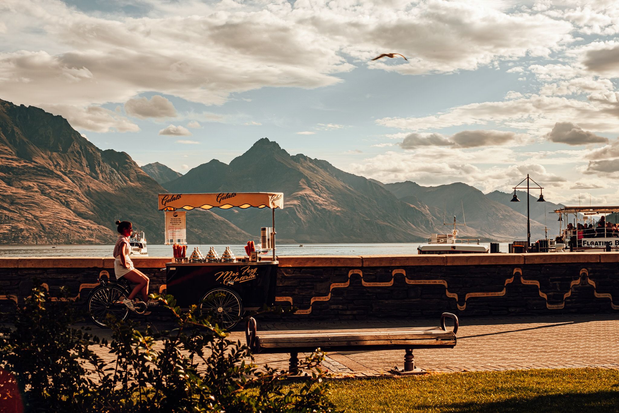 Scenic mountain landscape with an orange gantry crane at a port terminal in golden sunset light.