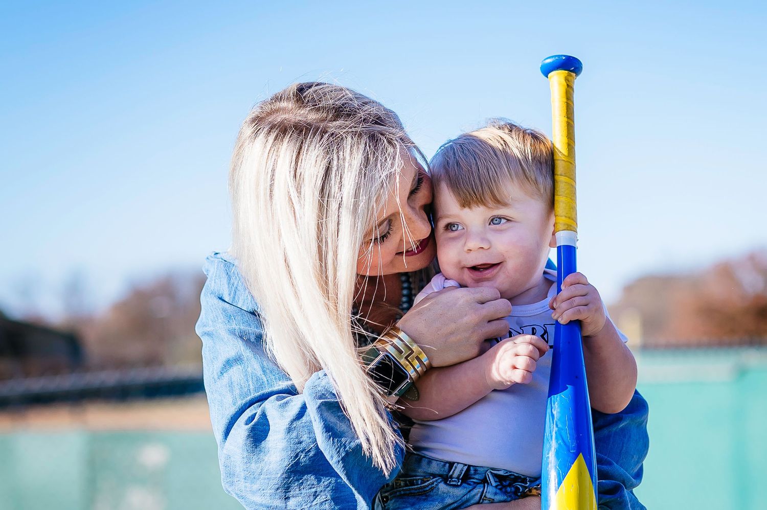 mom and son with baseball bat celebrating first birthday
