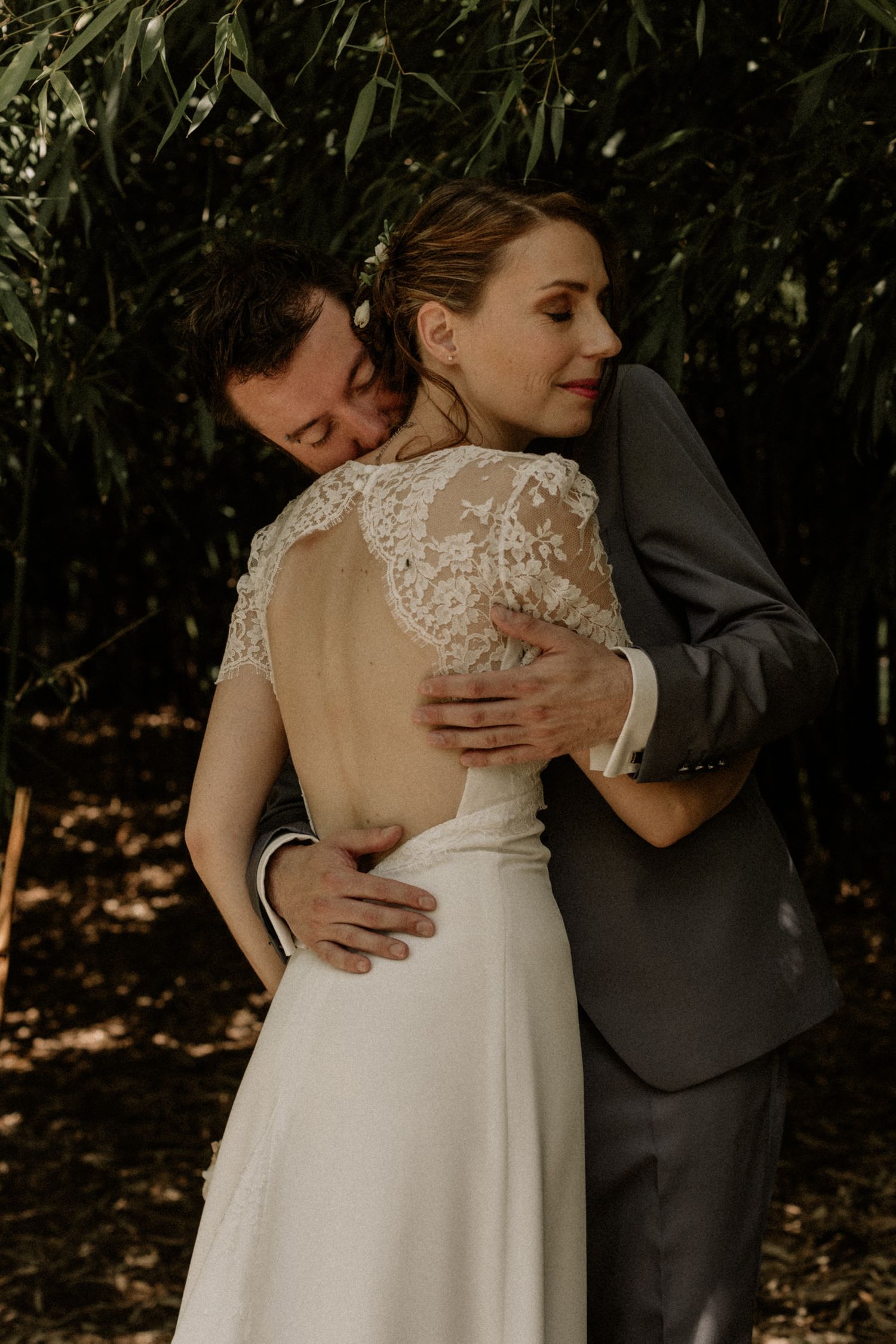 groom holding his bride and giving her a kiss in the neck after their wedding in bordeaux