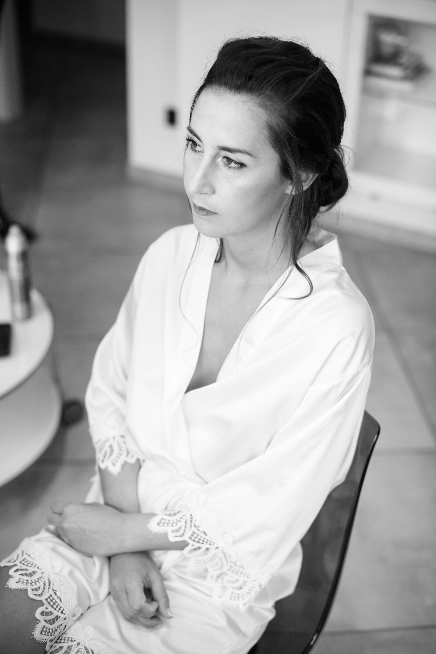 Classic black and white portrait of person in white lace-trimmed robe.