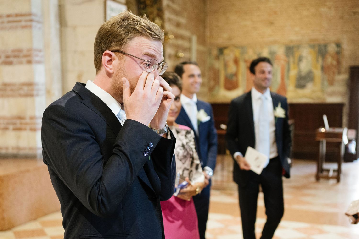 An emotional moment captured during a wedding ceremony in a historic church interior.
