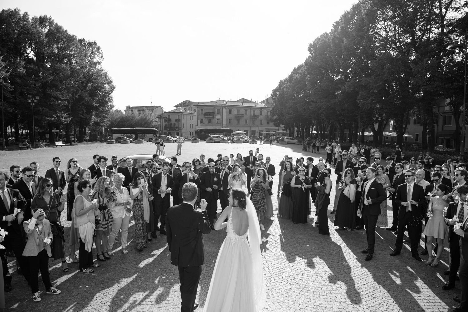 Wedding guests in formal attire mingle during an outdoor reception.