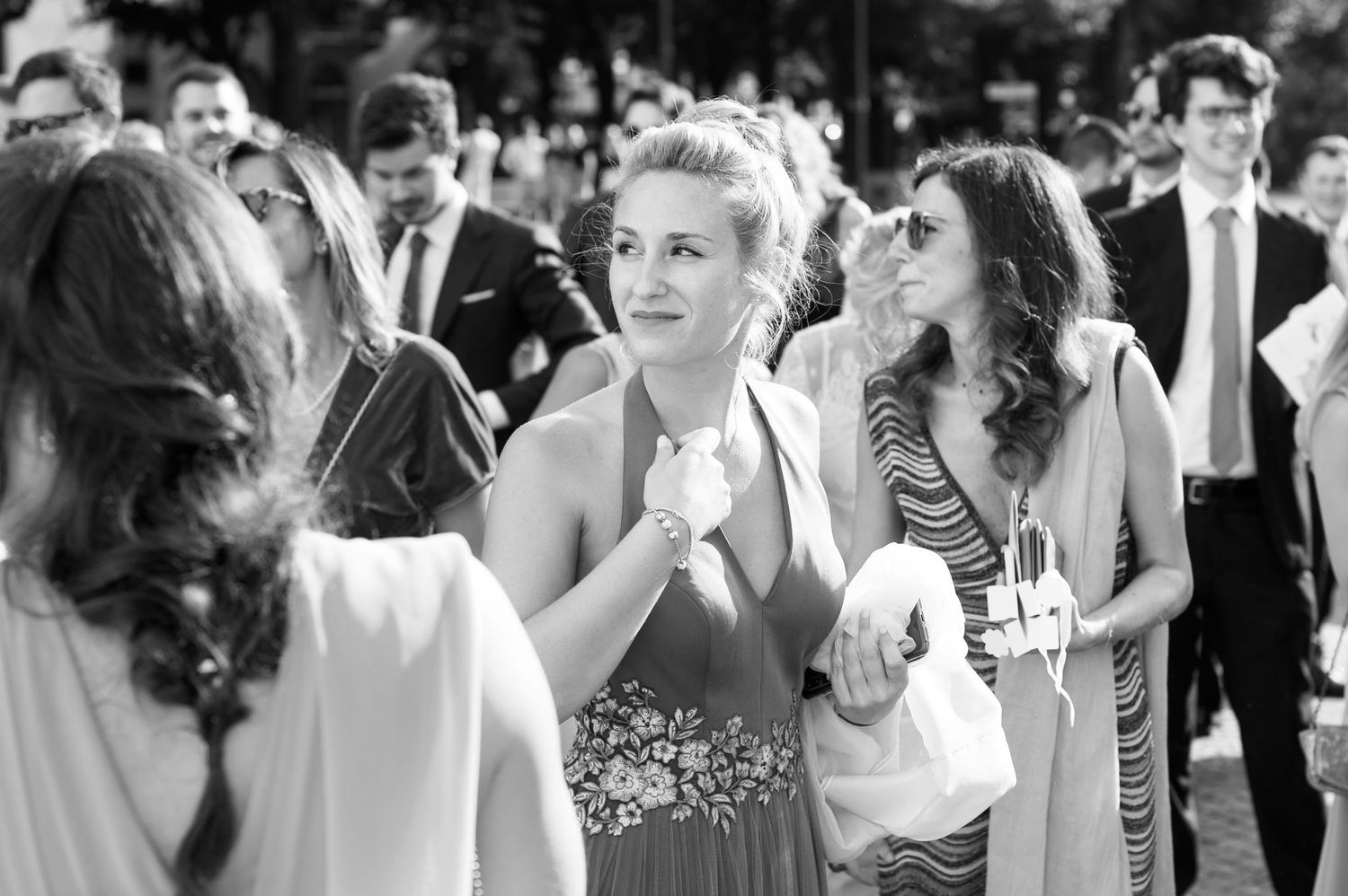 Black and white photo of wedding guests enjoying an outdoor celebration.