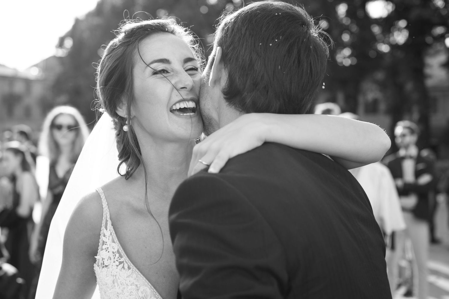 A joyful embrace captured in black and white during a wedding celebration.