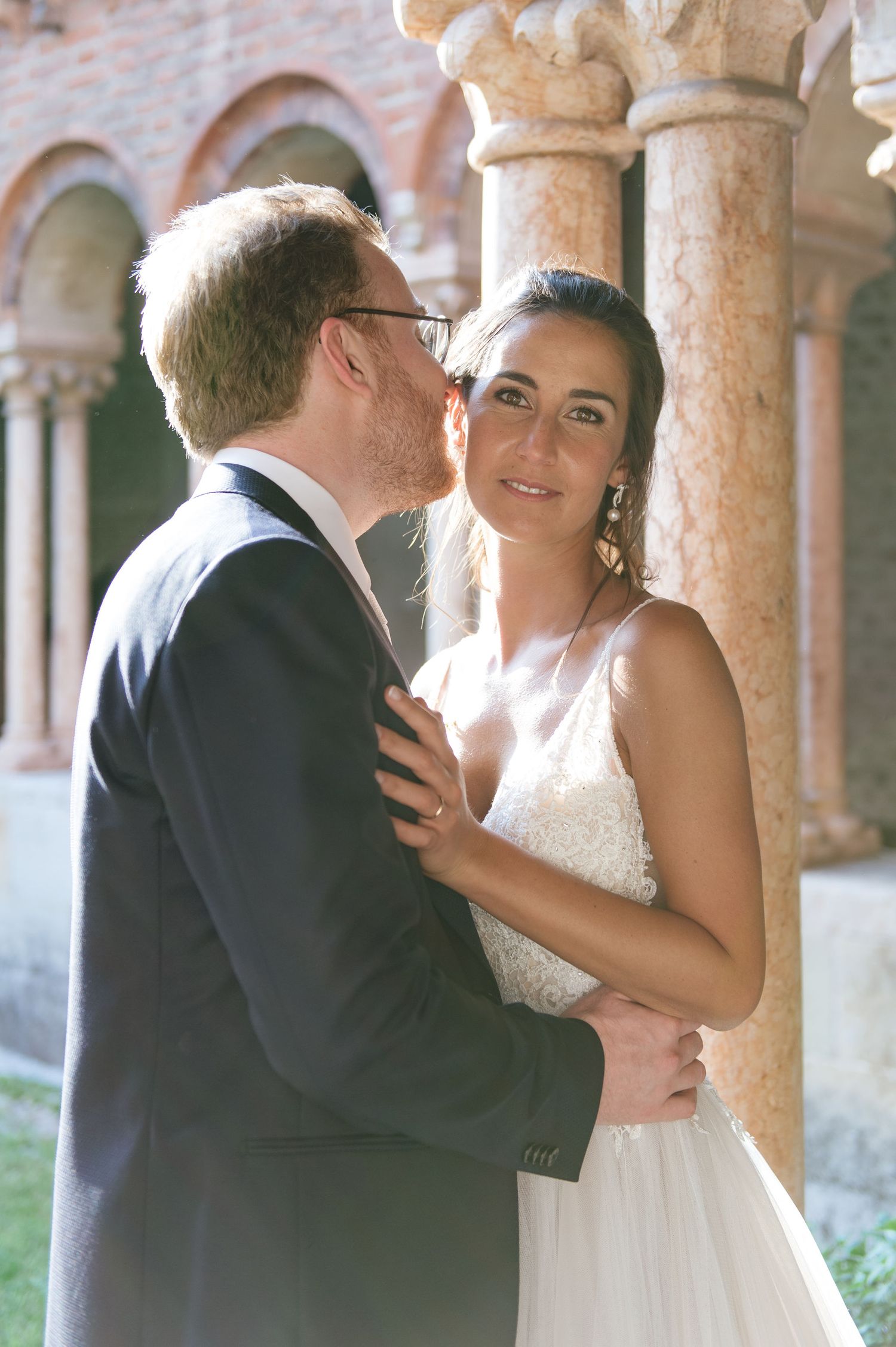 Intimate wedding portrait captured in a historic courtyard with stone architecture.