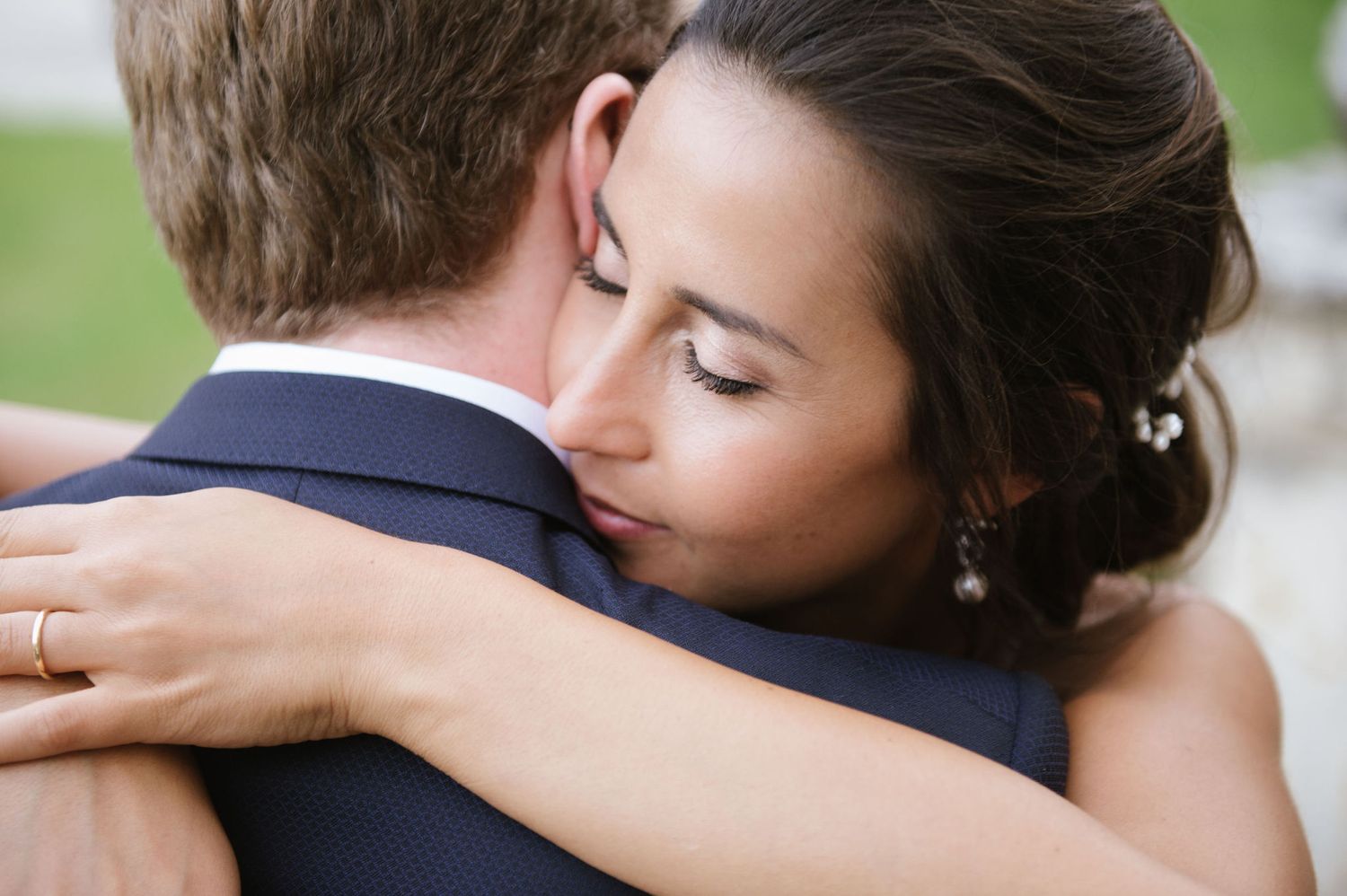 A tender moment is shared during a wedding embrace on a sunny afternoon.