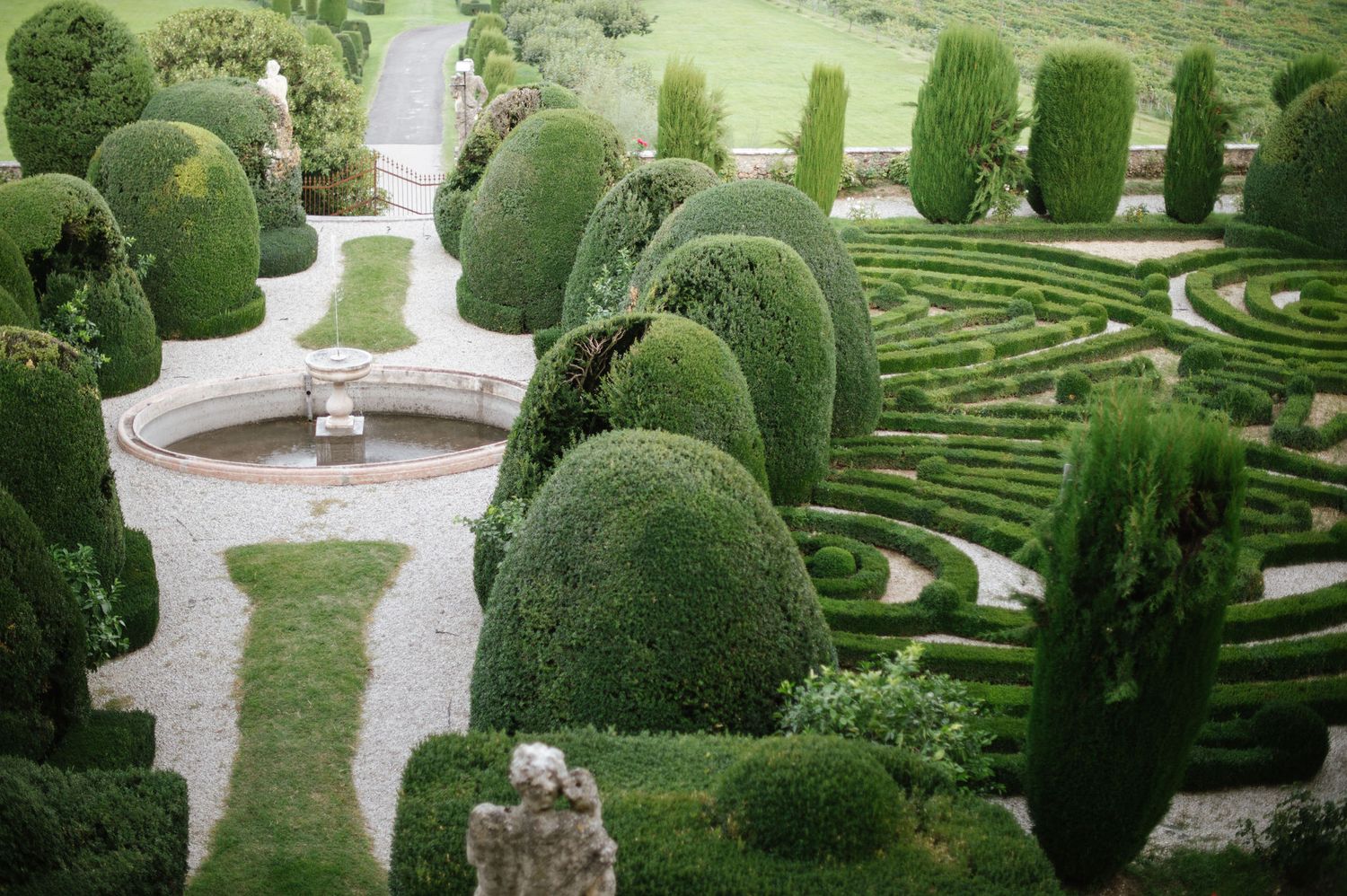 Aerial view of manicured hedges and formal garden maze patterns at a historic estate.