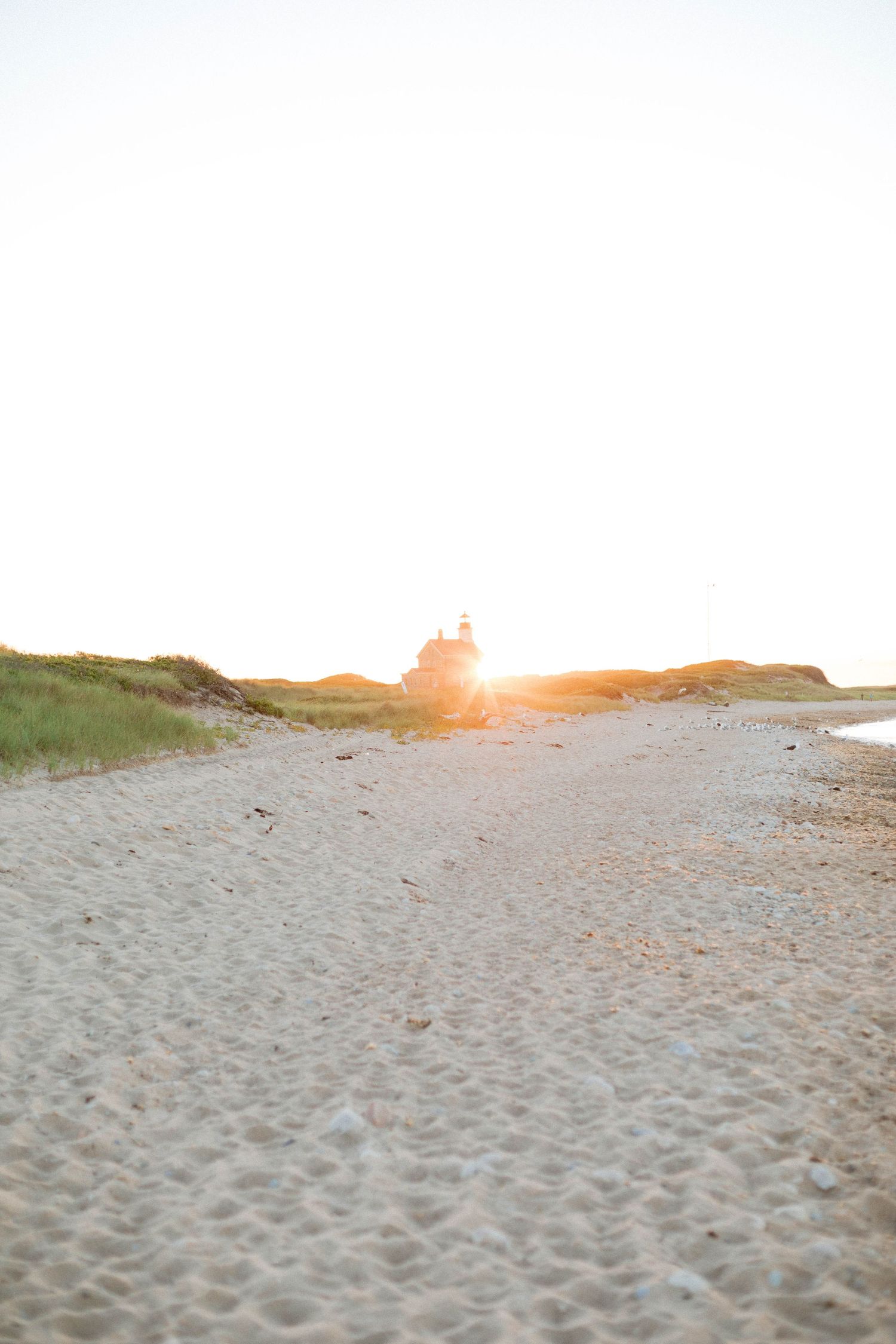 photo of lighthouse off in the distance with sun rays