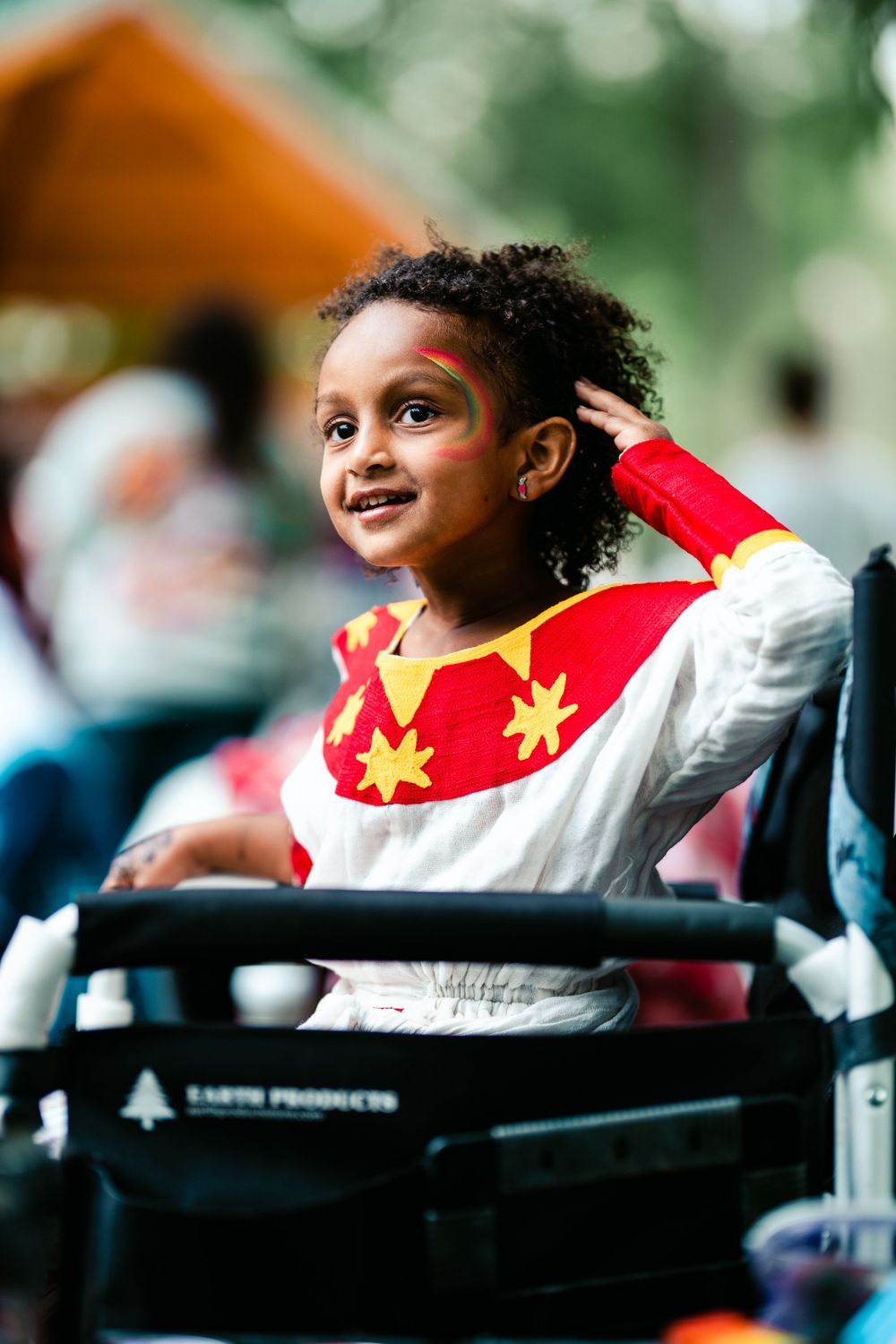 Young dancer in white and red costume with star decorations at cultural performance.
