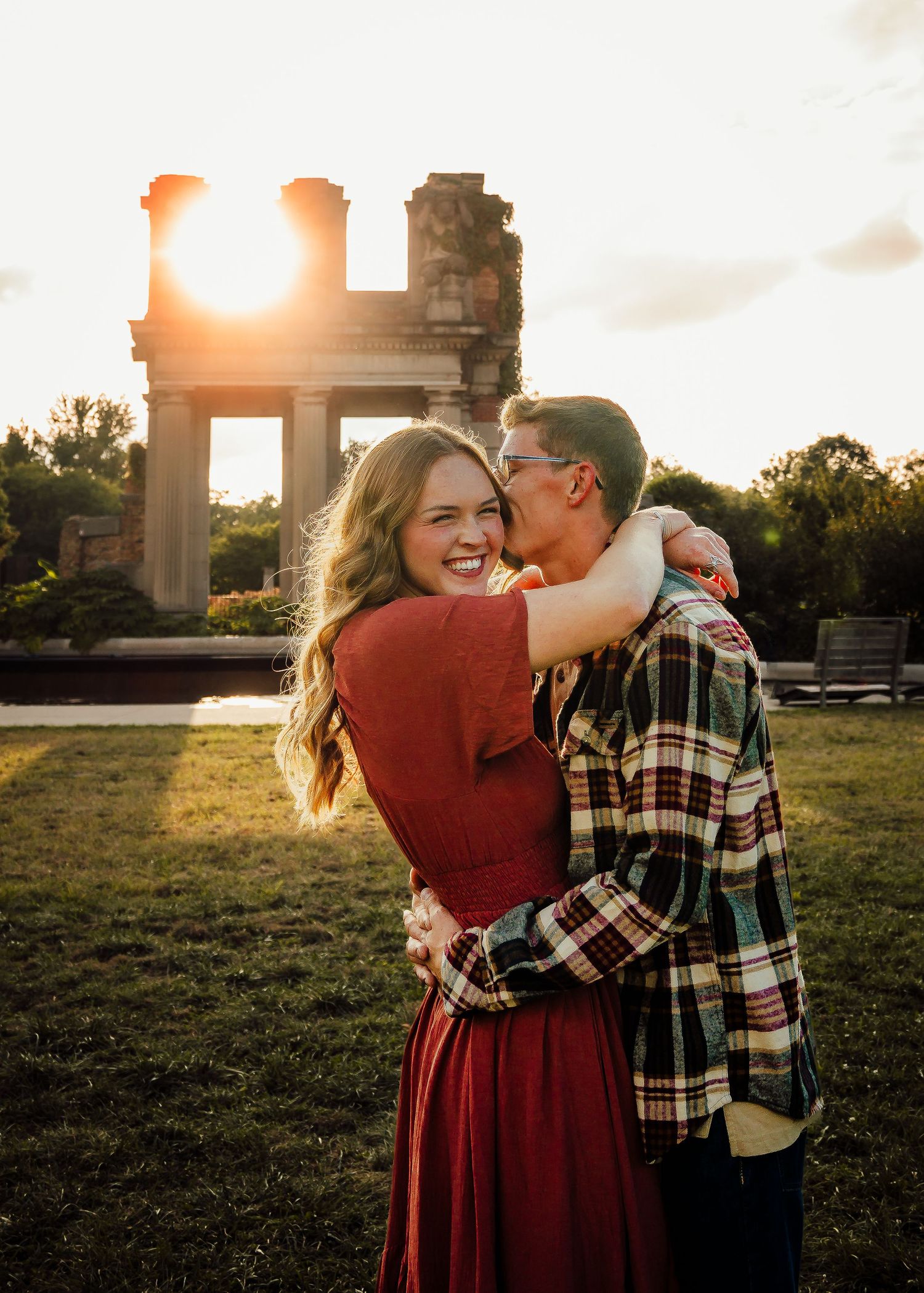 Guy whispers in girl's ear during couples photoshoot.