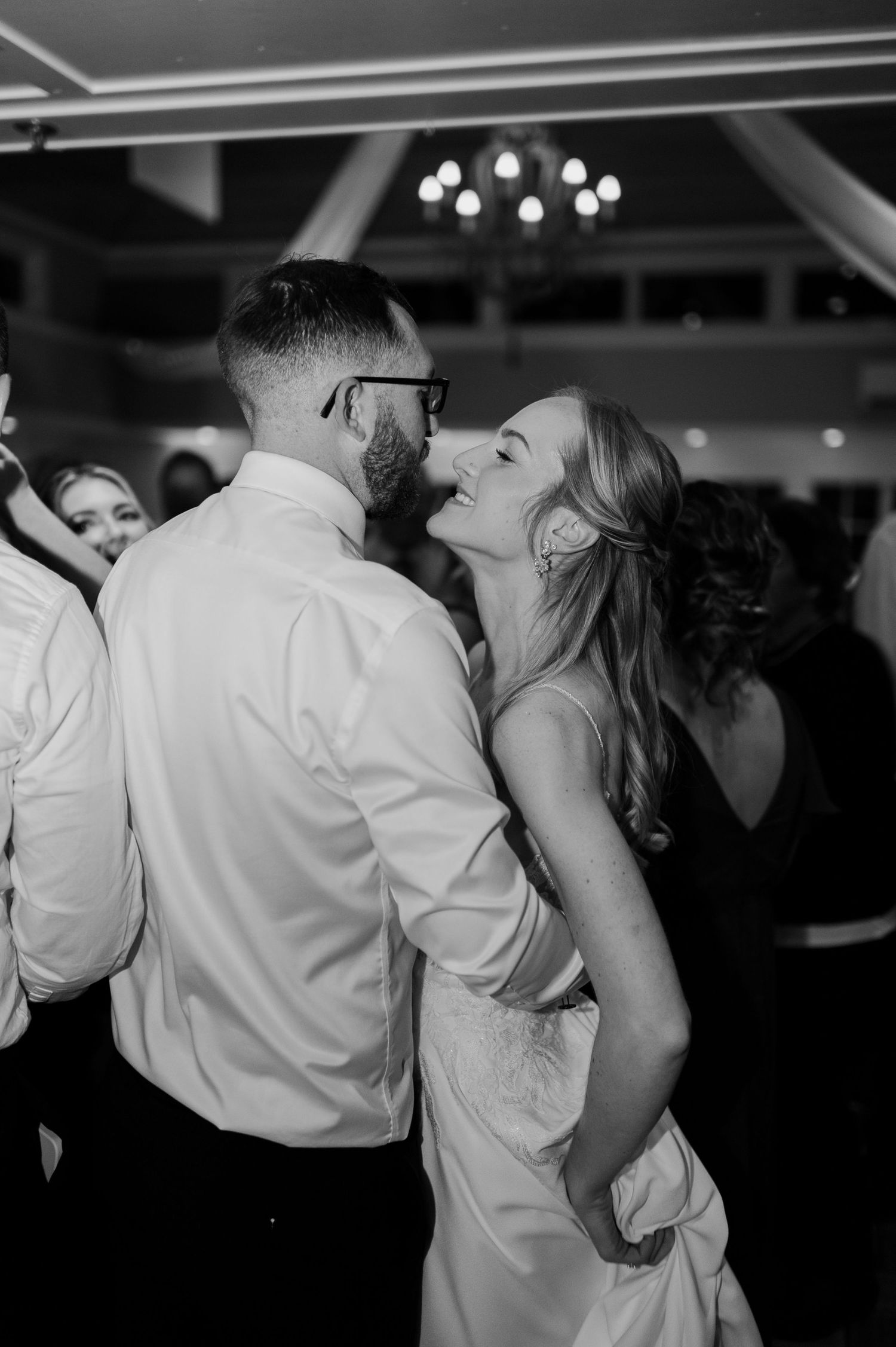 Intimate dance floor moment between wedding guests in black and white.