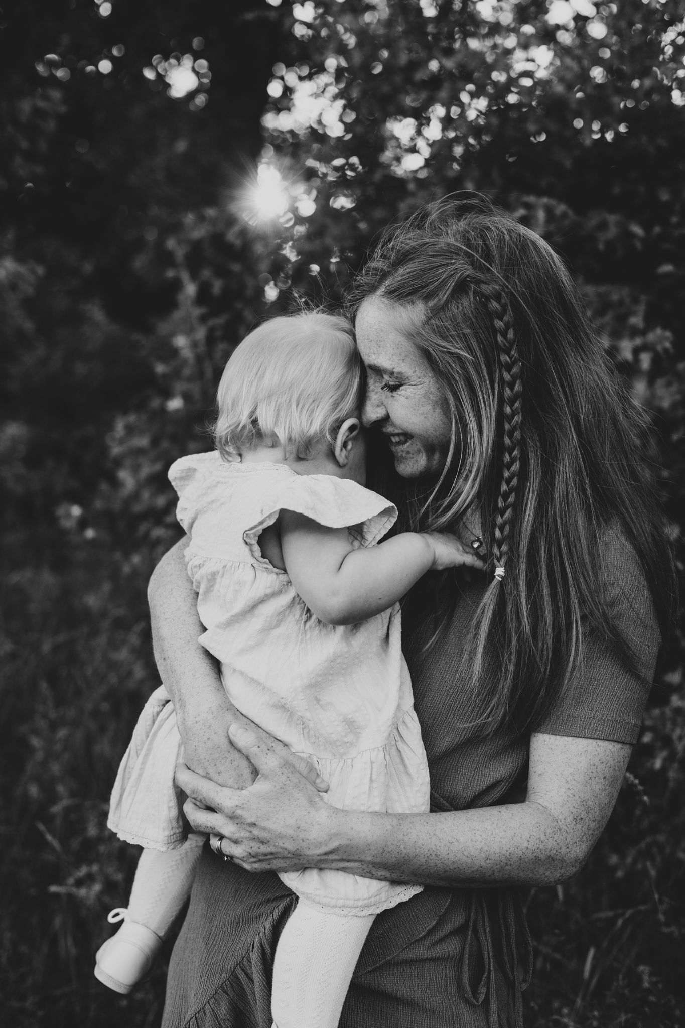 Svartvitt stämningsfullt porträtt av mamma och sin bebis.
