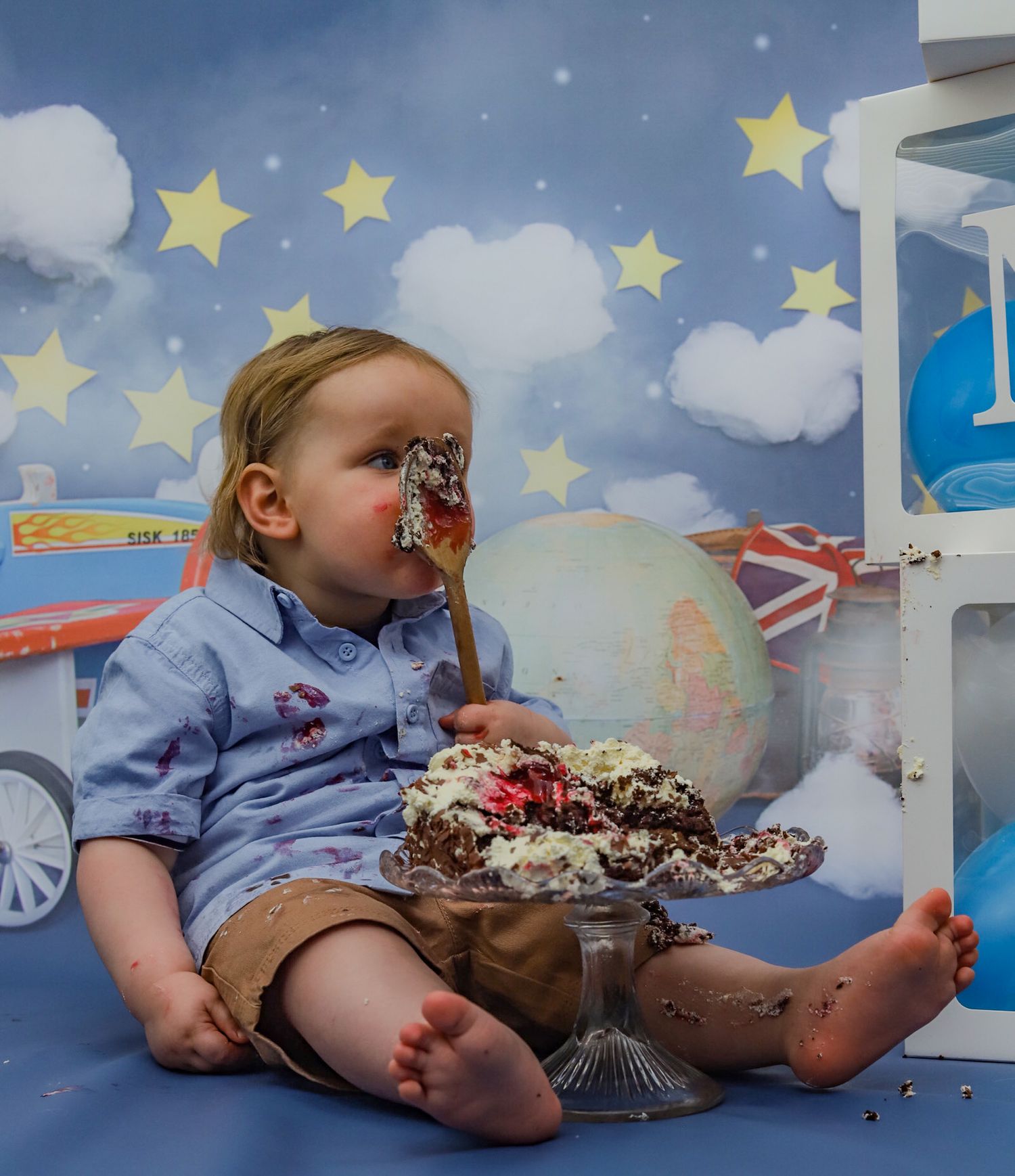 Cake smash photo with whimsical starry backdrop and globe decor.