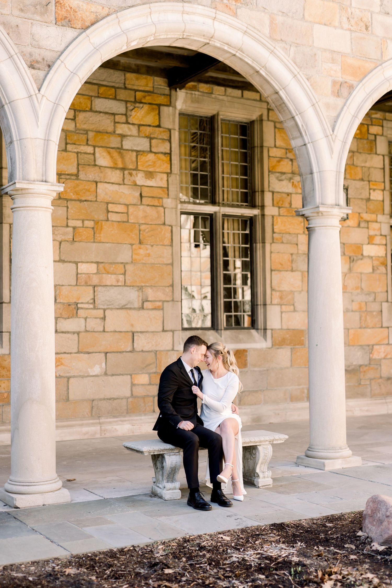 A bouquet of white flowers, including peonies and greenery, is displayed on a light background. Ann Arbor Law Quad Engagement Photos
