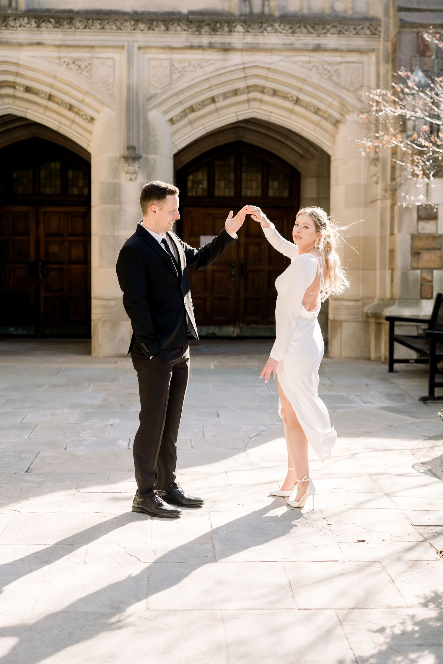 A bride and groom dance together in an outdoor setting. Ann Arbor Law Quad Engagement Photos