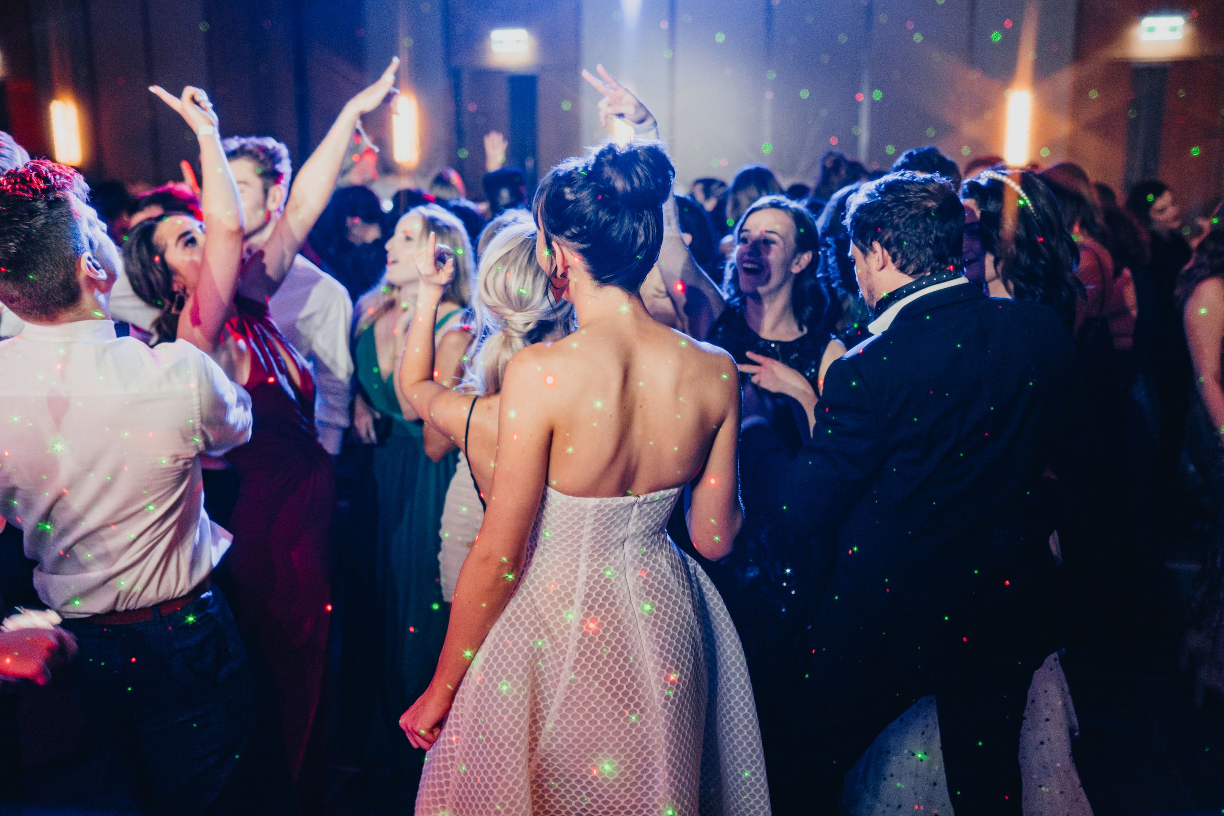 elegant young women dressed in formal dresses attending a glamorous ballroom event