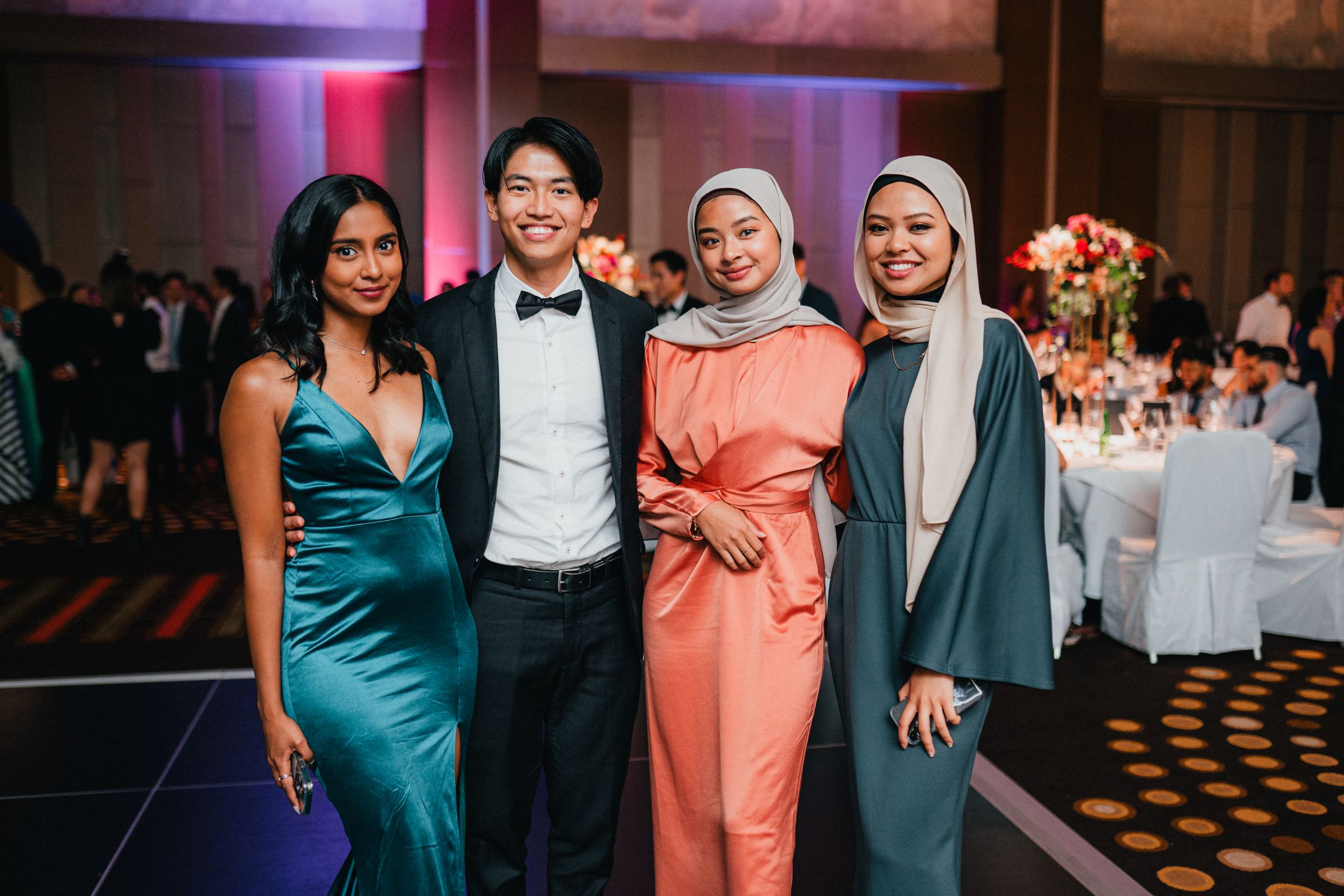 two elegant young women dressed in formal dresses attending a glamorous ballroom event