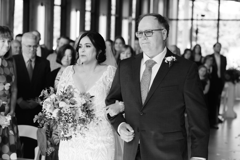 Bride and her father walk down aisle during summer wedding ceremony at Jorgensen Farms in Westerville, Ohio.