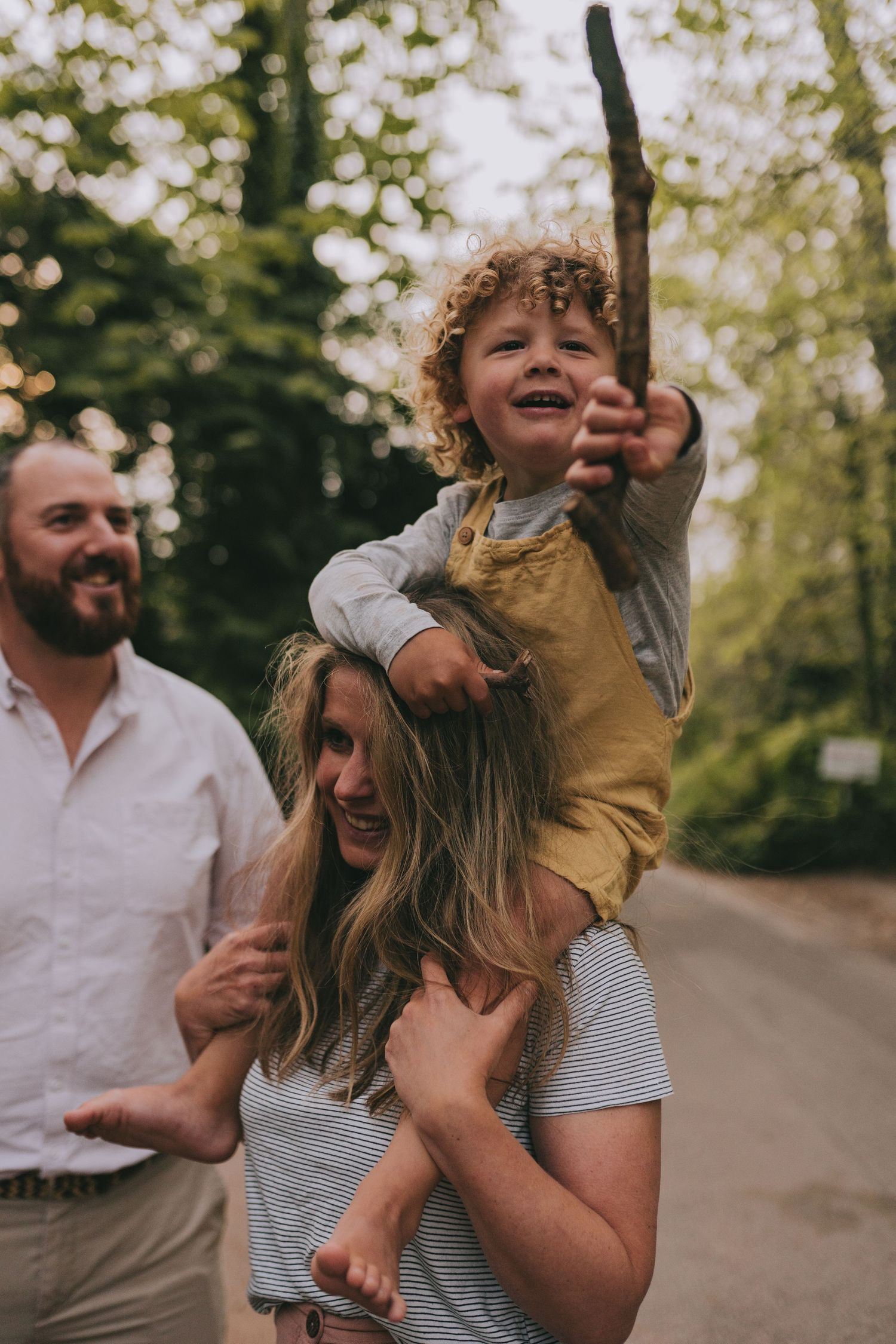 A joyful family moment captured on a tree-lined path.