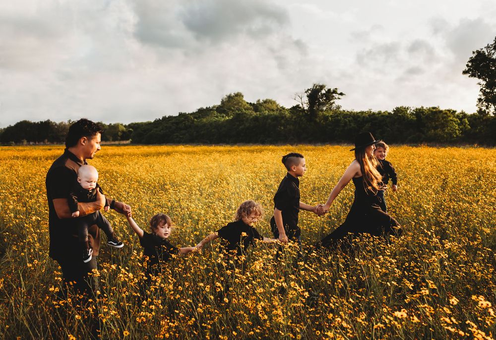 Family photos while walking in beautiful field of yellow flowers