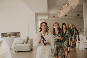 Group walking through bright modern room during wedding preparation.